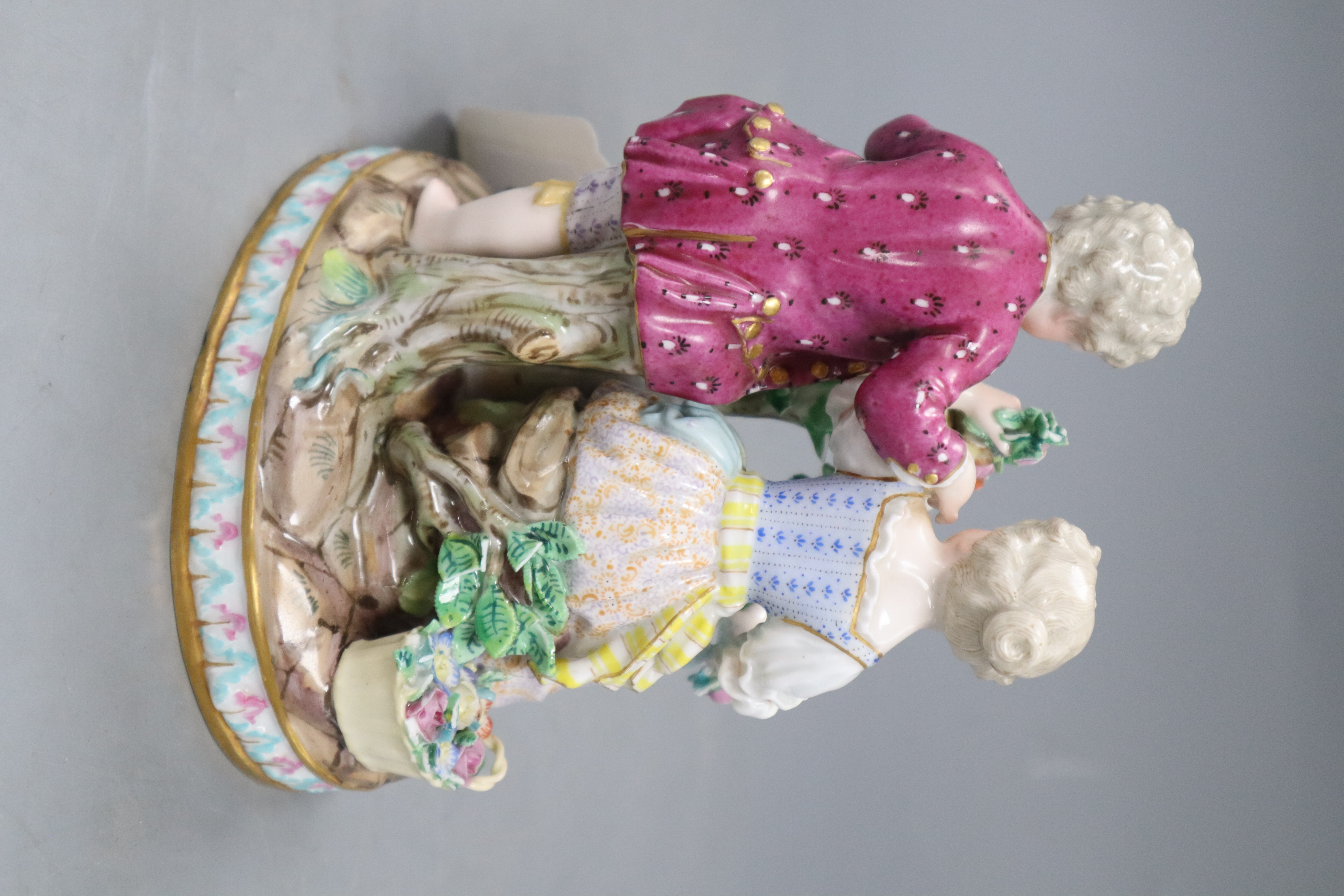 A Meissen figure group of a boy and girl with cage and garland, underglaze blue crossed sword marks, height 15cm